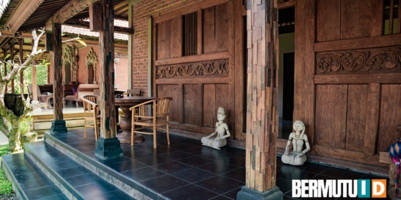 menempatkan patung khas bali di teras rumah